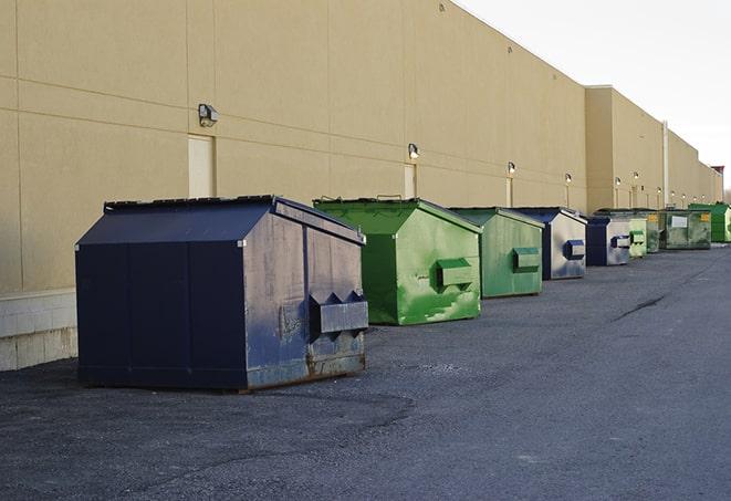 a row of yellow and blue dumpsters at a construction site in Beaumont, CA